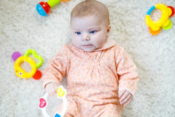 可愛いです赤ちゃん女の子遊びますとともにカラフルなラトルおもちゃ — ストック写真