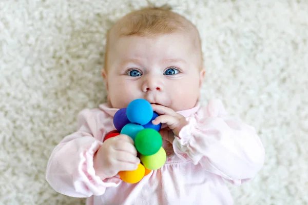Linda niña jugando con colorido juguete sonajero de madera — Foto de Stock
