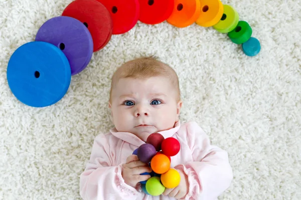 Bonito bebê menina brincando com colorido brinquedo chocalho de madeira — Fotografia de Stock