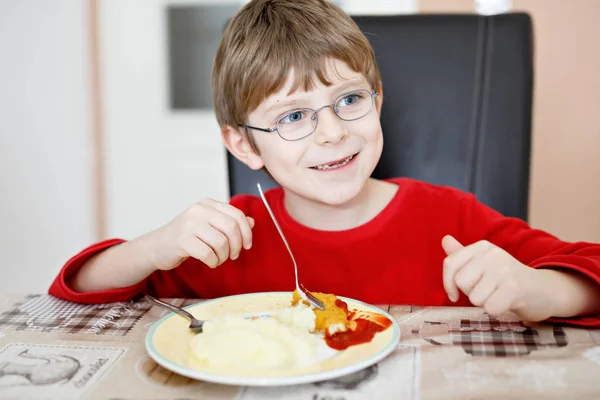 Adorable little school boy eating potato mash and chicken breast indoor — Stock Photo, Image