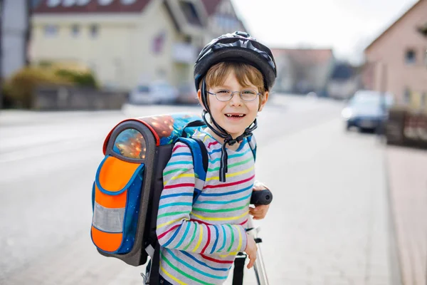 Petit garçon en casque chevauchant avec son scooter dans la ville — Photo