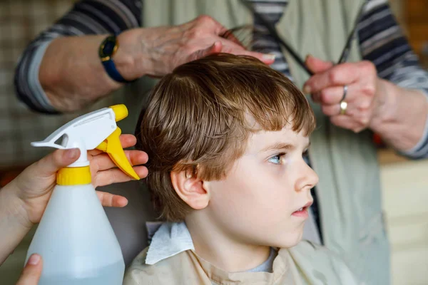 Vacker liten pojke med blont hår att få sin första frisyr. — Stockfoto