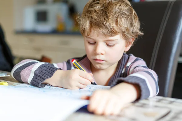 Mutlu okul çocuğu evde ödevini yapıyor. — Stok fotoğraf