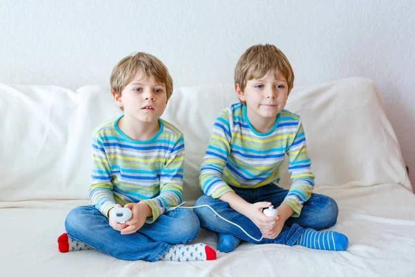 Двоє маленьких хлопчиків грають у відеогру вдома — стокове фото