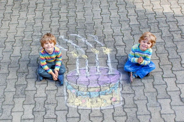 Two kid boys having fun with colorful birthday cake drawing with — Stock Photo, Image