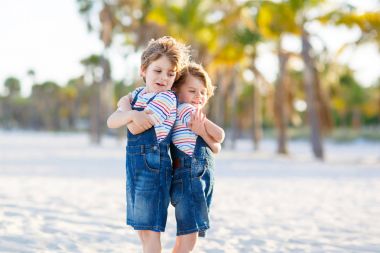 İki küçük çocuk tropik sahilde eğleniyor.