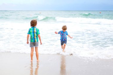 Portekiz tropikal plaj üzerinde çalışan iki çocuk çocuklar