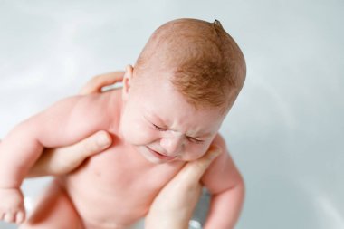 Şirin bebek çocuk alarak banyo ağlıyor. Kız mı erkek gözyaşları ile