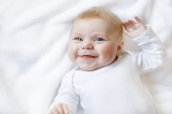 Meisje van de baby dragen witte handdoek of winter overal in witte zonnige slaapkamer — Stockfoto