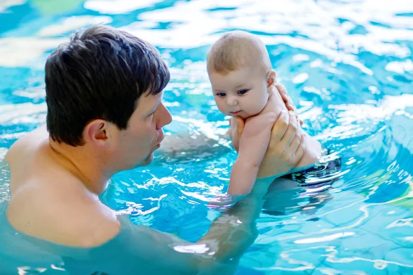 Feliz padre de mediana edad nadando con lindo bebé adorable en la piscina . — Foto de Stock