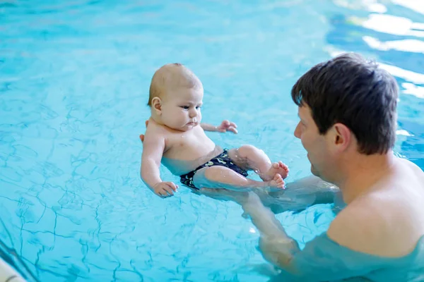 Szczęśliwy ojciec średnim wieku pływanie z cute adorable baby w basenie. — Zdjęcie stockowe