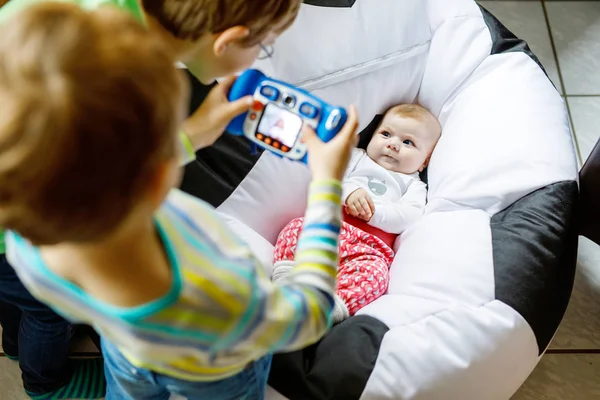 Dois irmãos crianças meninos tirando foto com câmera de brinquedo de bebê bonito menina . — Fotografia de Stock