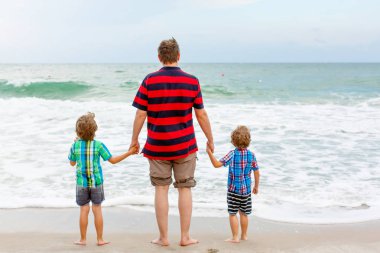 İki küçük çocuk çocuklar ve babası okyanus plaj