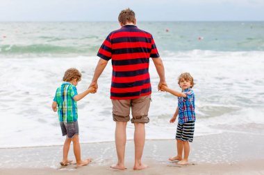 İki küçük çocuk çocuklar ve babası okyanus plaj