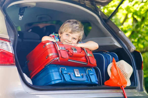 Pequeño niño sentado en el maletero del coche justo antes de salir para vaca — Foto de Stock