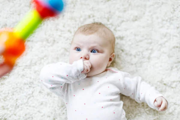 Schattig baby meisje spelen met kleurrijke rammelaar speelgoed — Stockfoto