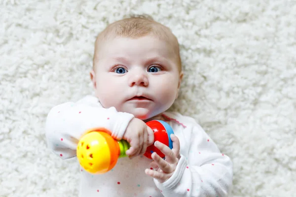 Roztomilé dítě dívka hrát s barevným chrastítko hračka — Stock fotografie