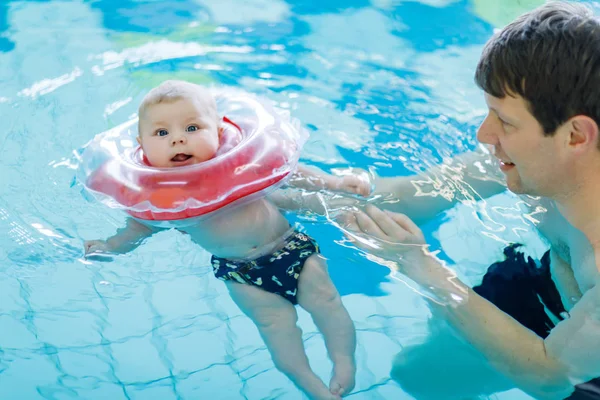 Счастливый отец среднего возраста плавает с милым очаровательным ребенком в бассейне . — стоковое фото