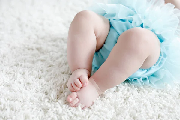 다리와 발 청록색 투투 치마를 입고 흰색 바탕에 아기 여자의 클로즈업. — 스톡 사진