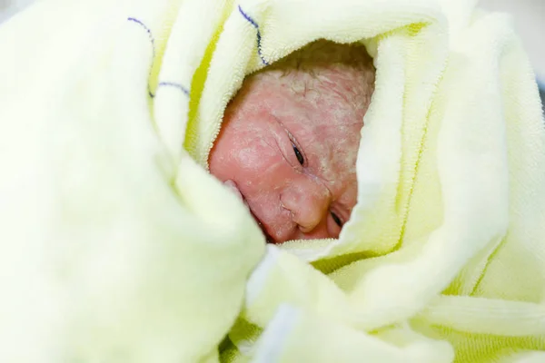 Newborn baby child seconds and minutes after birth wrapped in towel — Stock Photo, Image