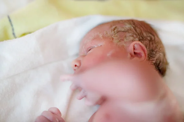 Bambino appena nato secondi e minuti dopo la nascita sdraiato su un asciugamano — Foto Stock