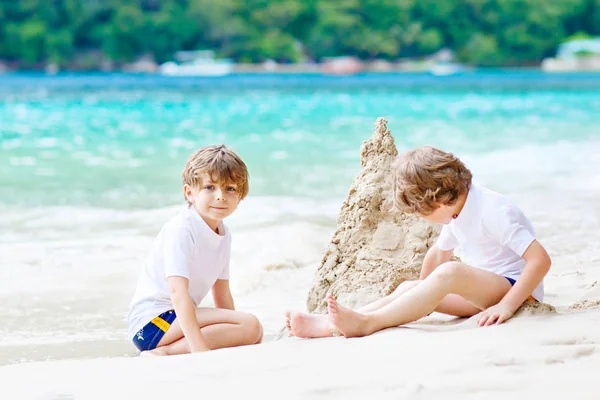 Two kid boys building sand castle on tropical beach — Stock Photo, Image