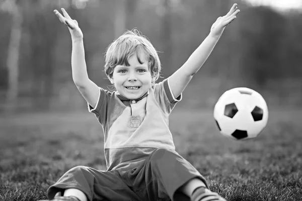 Kleiner netter Junge von 4 Jahren spielt Fußball mit Fußball auf dem Feld, im Freien — Stockfoto