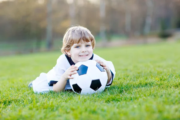 Little cute kid boy of 4 playing soccer with football on field, outdoors — Stock Photo, Image