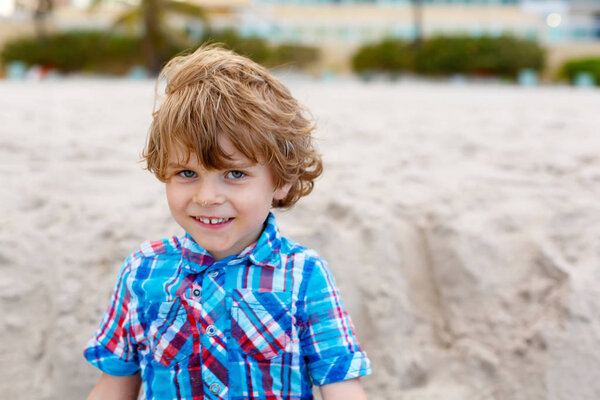 little kid boy running on the beach of ocean