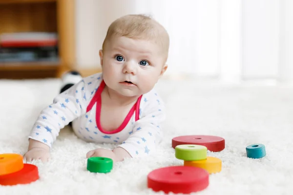 Bonito bebê menina brincando com colorido brinquedo chocalho de madeira — Fotografia de Stock