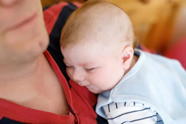 Feliz padre joven orgulloso sosteniendo pequeña hija durmiente, retrato familiar juntos . — Foto de Stock