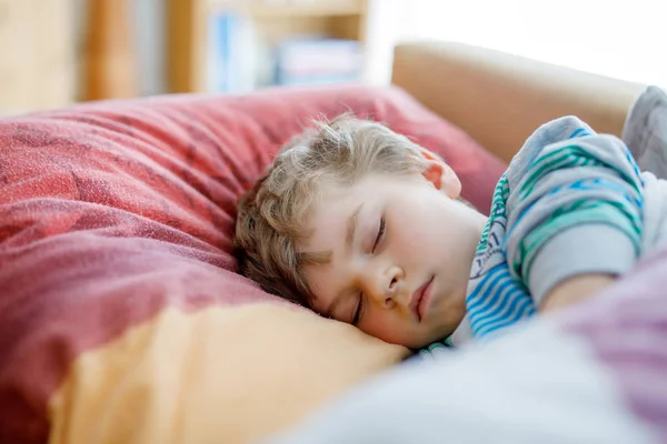 Pequeño niño preescolar triste durmiendo. Cansado escolar descansando después de las clases escolares . — Foto de Stock