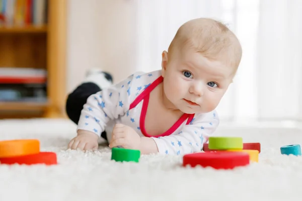 Χαριτωμένο μωρό κορίτσι παίζει με το παιχνίδι πολύχρωμο Ξύλινη κουδουνίστρα — Φωτογραφία Αρχείου