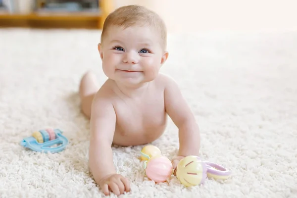 Schattig baby meisje spelen met kleurrijke pastel vintage rammelaar speelgoed — Stockfoto