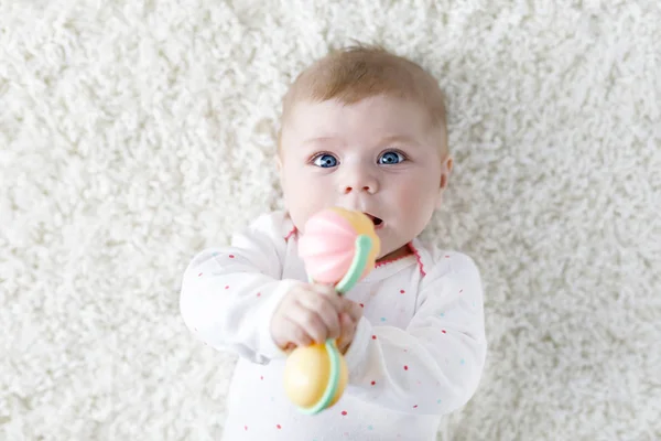 Cute baby girl playing with colorful pastel vintage rattle toy — Stock Photo, Image