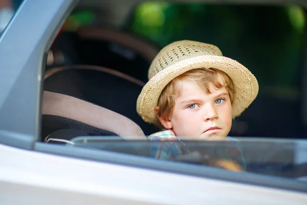 Smutné, unavené dítě chlapec sedí v autě v dopravní zácpě — Stock fotografie