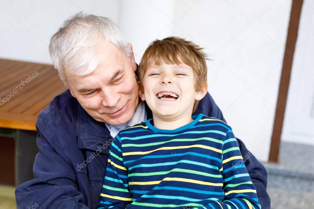 Laughing grandfather with his grandson as they play together.