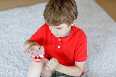 Tri kıpır el Spinner ile kapalı oynayan okul çocuk