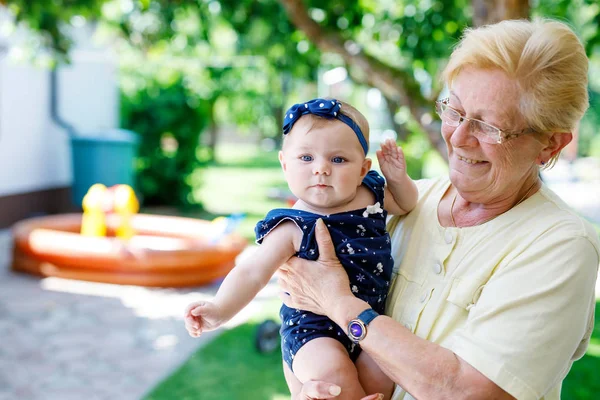 Cute little baby girl with grandmother on summer day in garden — Stock Photo, Image