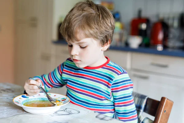 Schattige kleine jongen van de school groentesoep overdekt eten. — Stockfoto