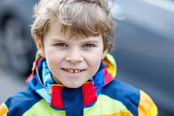 Ενεργή σχολική παιδί αγόρι στο πολύχρωμο casual ρούχα ιππασίας με σκούτερ του στην πόλη — Φωτογραφία Αρχείου