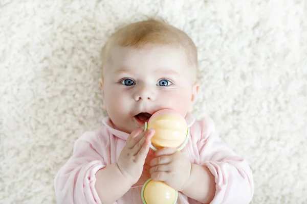 Linda niña jugando con colorido pastel vintage sonajero juguete — Foto de Stock