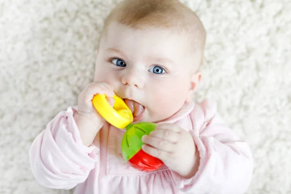 Cute baby girl playing with colorful pastel vintage rattle toy — Stock Photo, Image