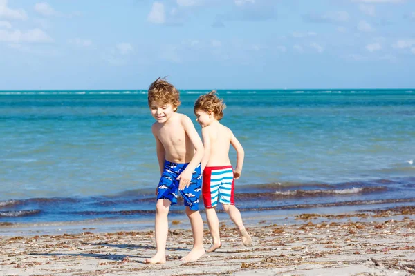 Dwójka małych chłopców bawiących się na tropikalnej plaży — Zdjęcie stockowe