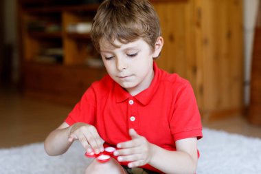 Tri kıpır el Spinner ile kapalı oynayan okul çocuk