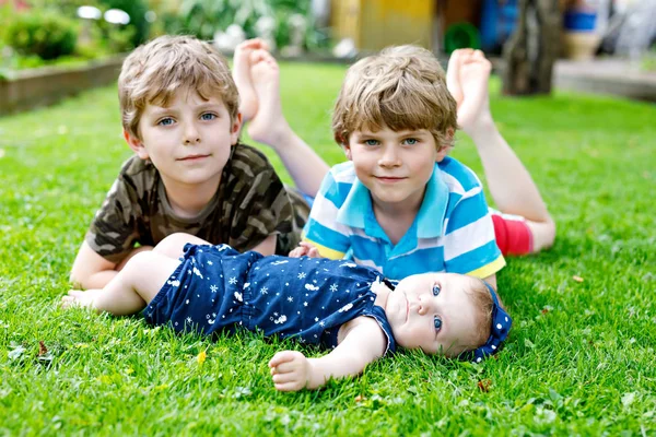 Two little happy kid boys with newborn baby girl, cute sister. — Stock Photo, Image