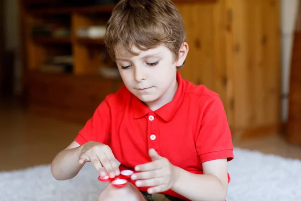 Dziecko szkoły gry z Tri Fidget dłoni łukiem w pomieszczeniach — Zdjęcie stockowe