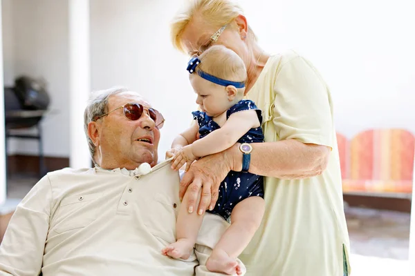 Cute little baby girl with grandmother and grandfather on summer day in garden — Stock Photo, Image