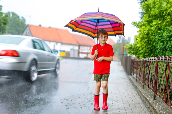 Kızıl yağmur botları ve şemsiye ile yürüyüş çocuk çocuk — Stok fotoğraf