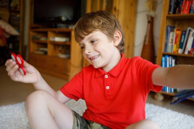 Tri kıpır el Spinner ile kapalı oynayan okul çocuk